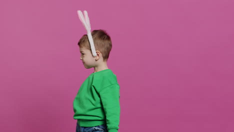 Cute-little-boy-wearing-fluffy-bunny-ears-in-studio-and-waving