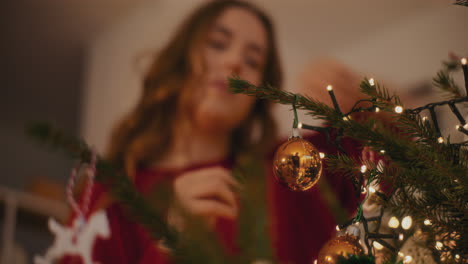 Frau-Bindet-Christbaumkugel,-Während-Sie-Den-Weihnachtsbaum-Schmückt