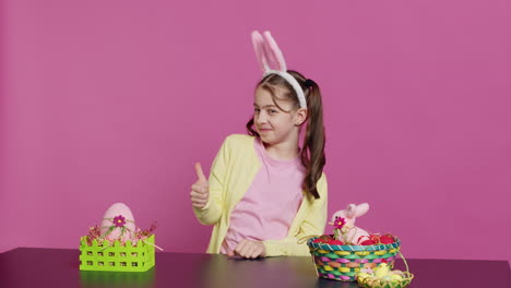 Happy-schoolgirl-with-bunny-ears-showing-thumbs-up-sign