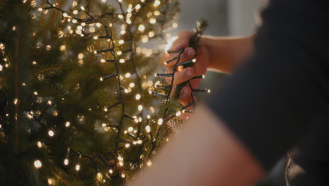 Mann-Mit-Leuchtenden-LED-Lichtern,-Die-Den-Weihnachtsbaum-Schmücken