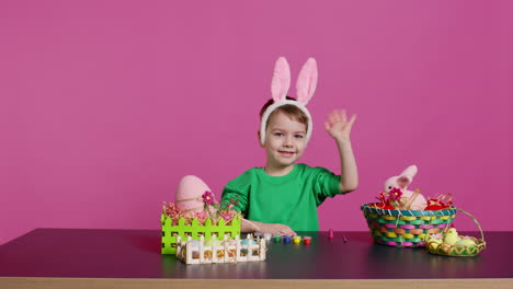 Young-small-kid-placing-bunny-ears-on-his-head-in-studio