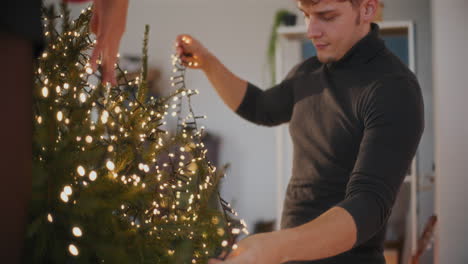 Paar-Mit-LED-Lichtern,-Die-Den-Weihnachtsbaum-Schmücken