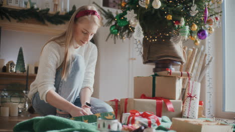Beautiful-young-woman-wrapping-Christmas-gifts-at-home