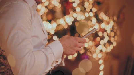 Man-using-digital-tablet-at-illuminated-home-during-Christmas