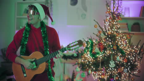 Mann-Tanzt,-Während-Er-Zu-Weihnachten-Gitarre-Im-Beleuchteten-Haus-Spielt