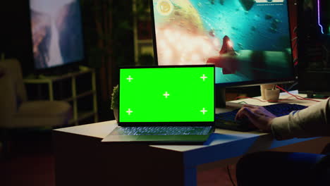 Mockup-laptop-next-to-man-playing-high-FPS-singleplayer-videogame-with-spaceship