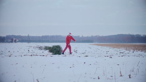 Hombre-Tirando-De-Trineo-Con-árbol-De-Navidad-En-El-Paisaje-Cubierto-De-Nieve.