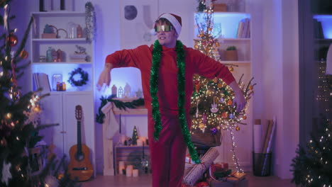 Exhilarated-man-in-Santa-hat-and-sunglasses-dancing-at-home