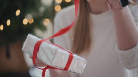 Glückliche-Frau,-Die-Zu-Hause-Ein-Verpacktes-Weihnachtsgeschenk-öffnet
