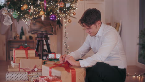 Glückliches-Binden-Eines-Bandes-An-Einer-Verpackten-Geschenkbox-Zu-Hause-Während-Der-Weihnachtszeit