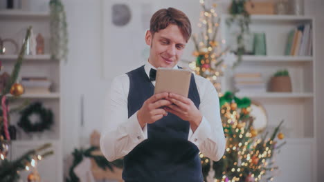 Hombre-Feliz-Video-Chat-En-Tableta-Digital-En-Casa-Durante-La-Navidad