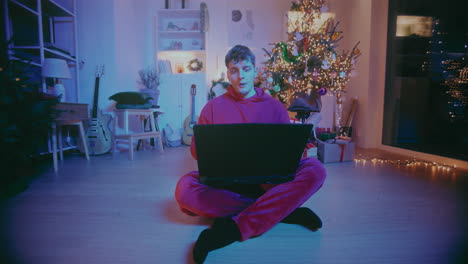 Trabajador-Independiente-Relajado-Cerrando-La-Computadora-Portátil-Mientras-Está-Sentado-En-Casa-Durante-La-Navidad