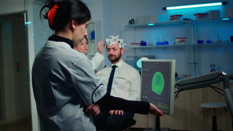 Woman-researcher-looking-at-monitor-analysing-brain-scan