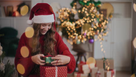 Aufgeregte-Frau-Mit-Weihnachtsmütze-Fängt-Geschenkboxen-Im-Dekorierten-Zuhause