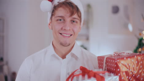 Handsome-man-looking-at-Christmas-gifts-at-home