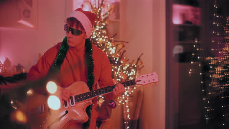 Man-playing-guitar-at-home-during-Christmas