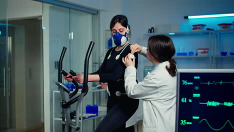 Woman-athlete-with-mask-running-on-cross-trainer