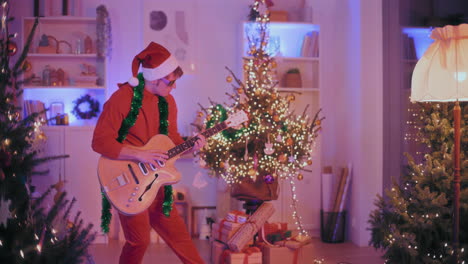 Man-playing-guitar-at-illuminated-home-during-Christmas