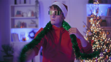 Excited-man-in-Santa-hat-and-sunglasses-dancing-at-home