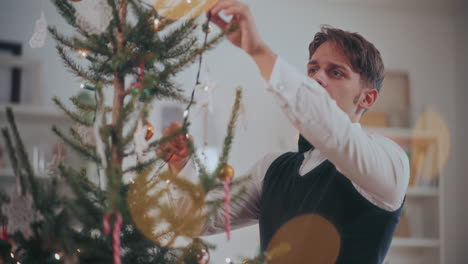 Man-placing-fairy-lights-on-Christmas-tree-at-home