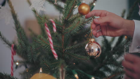 Hände-Schmücken-Den-Weihnachtsbaum-Zu-Hause-Mit-Silbernen-Kugeln