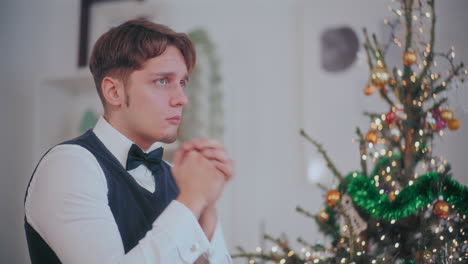 Depressed-man-at-home-with-Christmas-tree-in-background