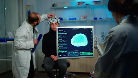 Science-doctor-looking-at-computer-with-medical-brain-scan-film