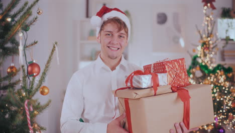 Handsome-man-carrying-various-Christmas-gifts-at-home