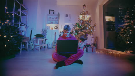 Glücklicher-Mann,-Der-Während-Weihnachten-Zu-Hause-Auf-Dem-Boden-Sitzt-Und-Einen-Laptop-Benutzt