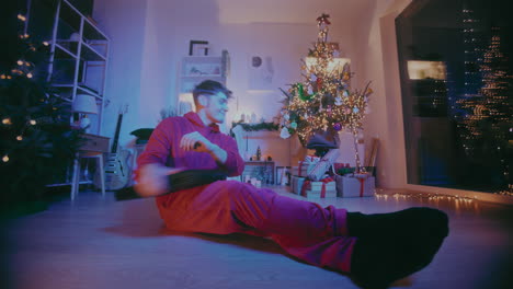 Entspannter-Männlicher-Freiberufler,-Der-Zu-Weihnachten-Zu-Hause-Seinen-Laptop-Auf-Dem-Boden-Schließt