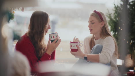 Woman-talking-to-sister-having-coffee-during-Christmas-at-home