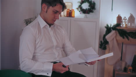Man-reading-letter-at-home-during-Christmas