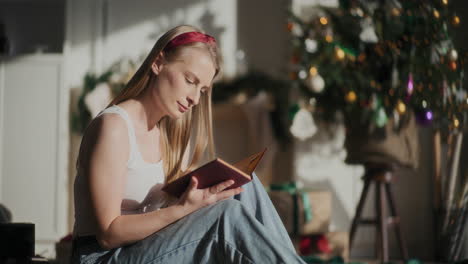 Attraktive-Frau-Liest-Ein-Buch,-Während-Sie-Zu-Weihnachten-Zu-Hause-Sitzt