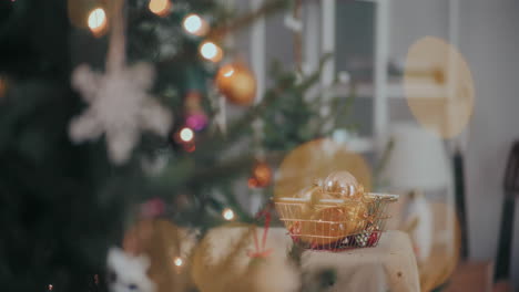 Männliche-Hand-Pflückt-Zu-Weihnachten-Christbaumkugel-Aus-Dem-Korb-Im-Beleuchteten-Haus