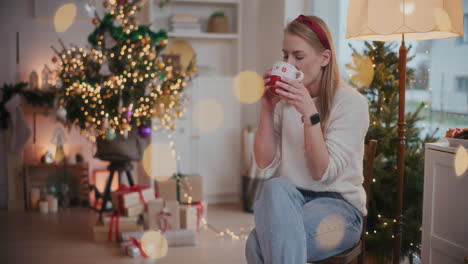 Attraktive-Frau-Trinkt-Zu-Weihnachten-Kaffee-Auf-Einem-Stuhl-Zu-Hause