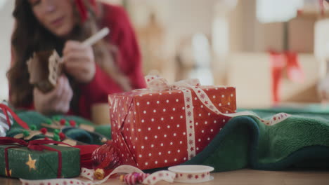 Weihnachtsgeschenke-Auf-Dem-Boden-Mit-Frau,-Die-Hausverzierung-Zu-Hause-Ausmalt
