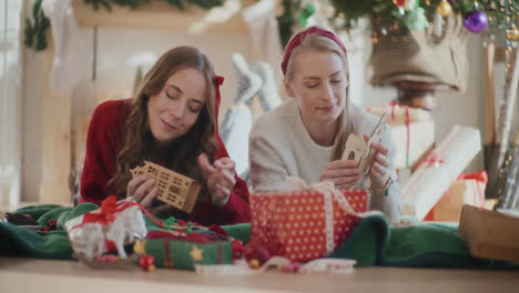 Sisters-making-cardboard-house-ornaments-during-Christmas-at-home