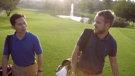 Slow-Motion-Shot-Of-Male-Golfers-Walking-Along-Fairway