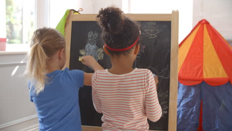 Two-Girls-Drawing-Picture-On-Blackboard-Shot-On-R3D