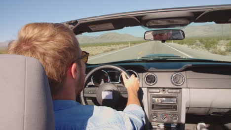 Hombre-En-Un-Automóvil-Descapotable-Conduciendo-Por-Una-Carretera-Abierta-Filmada-En-R3d