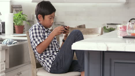 Junger-Asiatischer-Junge,-Der-Ein-Spiel-Auf-Einem-Mobilen-Gerät-Spielt,-Aufgenommen-Auf-R3D