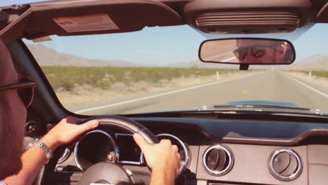 Man-In-Convertible-Car-Driving-Along-Open-Road-Shot-On-R3D