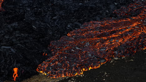 Unique-view-of-molten-lava-flow-burning-and-slowly-moving,-aerial-close-up-shot