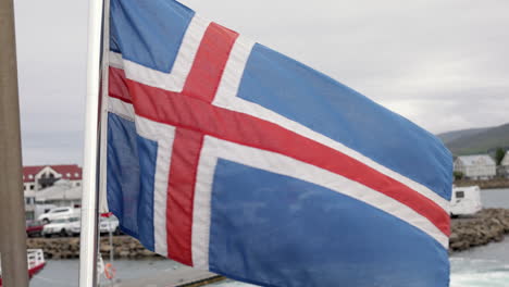 Flag-of-Iceland-waving-in-the-wind-on-a-ship-leaving-a-harbor,-close-up-shot