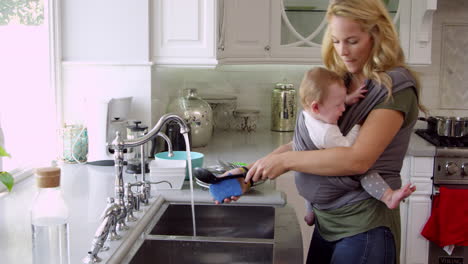 Busy-Mother-With-Baby-In-Sling-At-Home-Shot-On-R3D