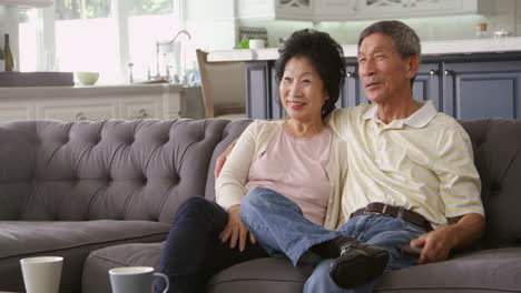 Älteres-Asiatisches-Paar-Zu-Hause-Auf-Dem-Sofa-Vor-Dem-Fernseher,-Aufgenommen-Auf-R3D