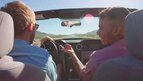 Two-Men-In-Convertible-Car-Driving-Along-Road-Shot-On-R3D