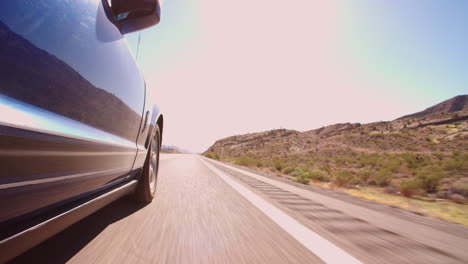 Low-Angle-View-Of-Car-Driving-Along-Country-Road-Shot-On-R3D