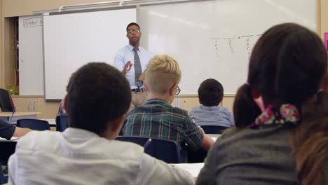 Kids-watch-teacher-in-math-class,-back-view,-shot-on-R3D