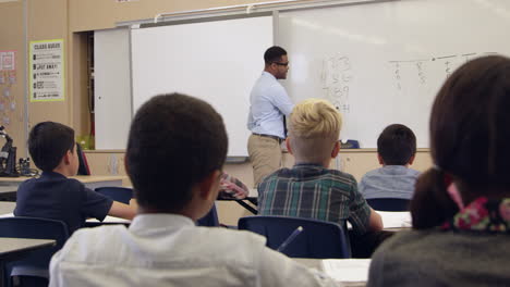 Teacher-asks-question-in-math-class,-back-view,-shot-on-R3D